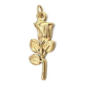 Close-up of a detailed golden rose metal pendant with polished flower and leaf design