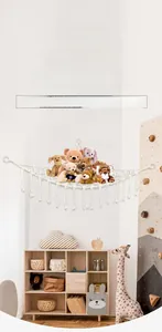 Detail of woven cotton triangle toy hammock with macrame tassels in child bedroom