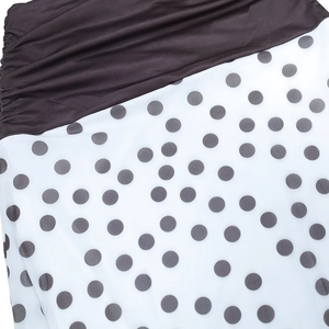 Detailed view of the gathered waist and gray polka dot print on high-quality fabric