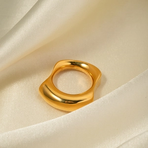 Minimalist 18k gold irregular wavy stainless steel ring displayed on white silk fabric