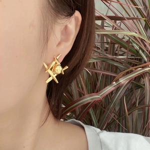 Modern 3D geometric gold-plated stainless steel earrings shown on model's ear
