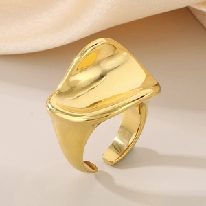 Close-up of wavy 18K gold plated stainless steel ring on elegant silk fabric