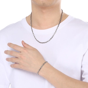 Polished silver stainless steel pig nose chain necklace and bracelet set on a model