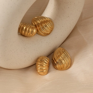 Vintage gold geometric striped earrings with wave texture on elegant fabric background