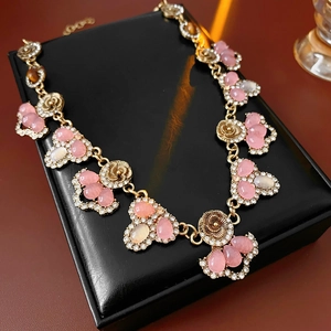 Detail of vintage flower necklace with pink gemstones and crystals on black leather box