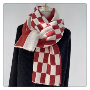 Close-up of soft red and white checkered knit scarf material on a fashion mannequin