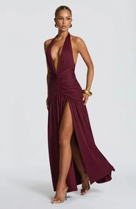 Detail of the elegant deep V-neck and pleated wine red fabric of the long evening dress