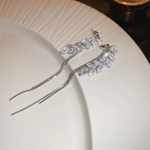 Detail of silver leaf earrings with sparkling zircon stones and long hanging tassels