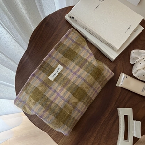 Flat lay of vintage plaid wool cosmetic bag with simple wish label on wooden table