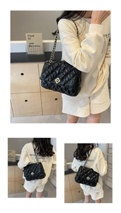 Detail of black quilted leather shoulder bag with gold floral clasp and chain strap