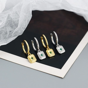 Detailed view of 925 silver starburst hoop earrings with green gemstone in gold and silver