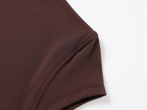 Macro shot of double-needle stitching and fine texture on a dark brown slim-fit T-shirt
