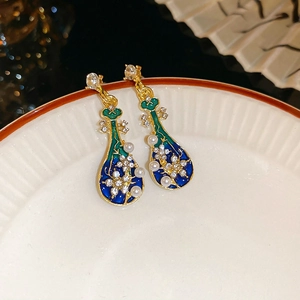 Detailed macro view of Pipa-shaped earrings with blue enamel, pearls and crystals