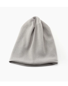 Detailed view of grey waffle-knit texture on a warm slouchy beanie hat for winter