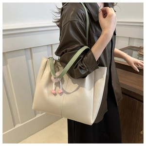 Grande borsa tote bianco crema con spalline verdi indossata da modella vista laterale