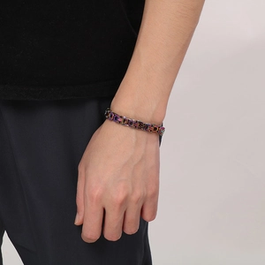 Close-up of a chunky rainbow stainless steel chain bracelet on a model wrist