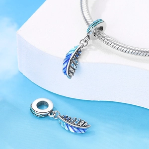 Detail of blue gradient enamel feather charm with pavé zircon stones on a bracelet