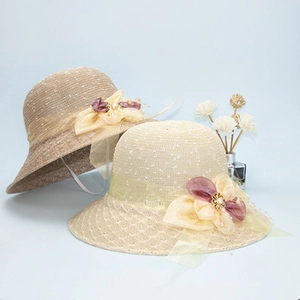 Detail of raffia sun hats featuring elegant chiffon flowers and delicate lace ribbons