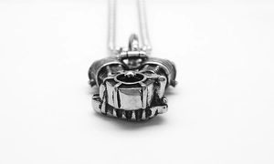 Detailed close-up of a silver motorcycle engine pendant in punk hip-hop style