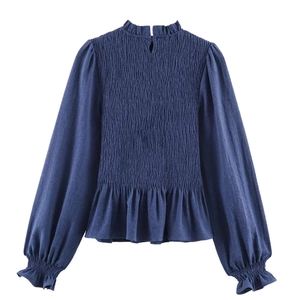 Detail of navy honeycomb blouse featuring ruffled high neck and smocked chest design