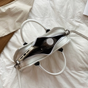 Top view of white PU leather crossbody bag showing internal storage space and long strap