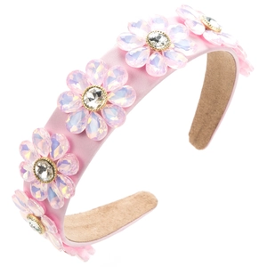 Detail eines rosa Satin-Haarreifs mit fünf funkelnden, irisierenden Kristallblumen
