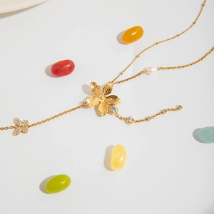 Detail der 18K vergoldeten Edelstahl Y-Kette mit Schmetterling-, Blumen- und Perlenanhänger