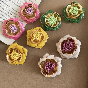 Gros plan de boucles d'oreilles fleurs vintage avec émail coloré et bords dorés