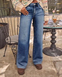 Buitenopname van high-waist jeans met wijde pijpen in medium wassing blauw met schoenen