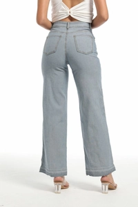 Detail view of the back pockets and distressed hem on light blue wide leg jeans