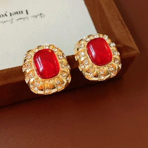 Detailansicht der Vintage-Ohrstecker in Gold mit roten Harzsteinen und glänzenden Strass