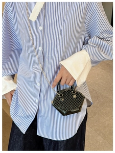 Detailed view of black geometric pattern mini bag with glossy PU texture and chain strap