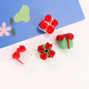 Macro detail of red and green glass Christmas gift box beads for DIY jewelry making