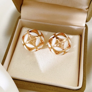 Gros plan de boucles d'oreilles vintage dorées en forme de fleur dans un écrin beige