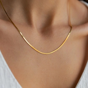 Close-up of a 18K gold plated stainless steel snake chain necklace on female model