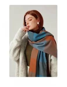 Close-up of elegant striped plaid scarf texture featuring soft cashmere-like fabric fringe
