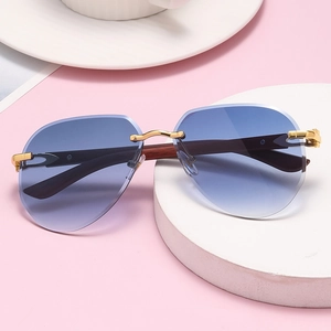 Detalle de gafas de sol sin montura con lentes azul degradado y varillas de madera y oro