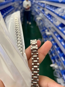 Close-up of polished silver stainless steel watch strap band with classic 3-link design