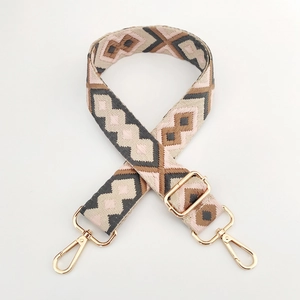 Detail of adjustable geometric diamond pattern bag strap with gold metal lobster clasps