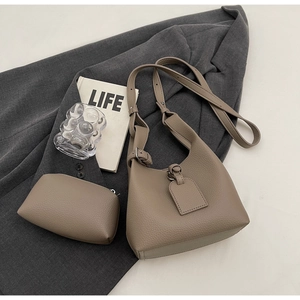 Detail of lychee pattern leather shoulder bag and pouch in taupe finish with life magazine