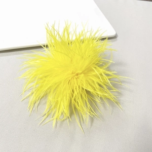 Detail of bright yellow ostrich feather brooch with soft texture and radial design