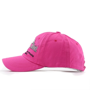 Detail of side embroidery on a washed rose red baseball cap with white background