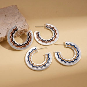 Minimalist C-shaped drop oil enamel hoop earrings with wavy patterns on a textured stone