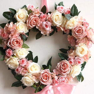 Heart-shaped wedding wreath with pink roses, hydrangeas and a satin ribbon bow