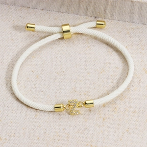 Detail of white braided cord bracelet with gold letter Z charm and sparkling crystals