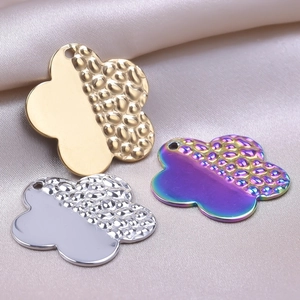 Polished flower pendants in gold silver and rainbow finish on silk background