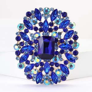 Detail of blue rhinestone brooch featuring a large oval crystal in a gold-plated setting
