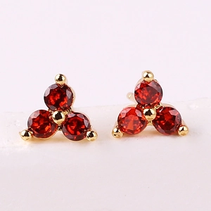 Detailed view of red gemstone clover stud earrings with elegant gold plating
