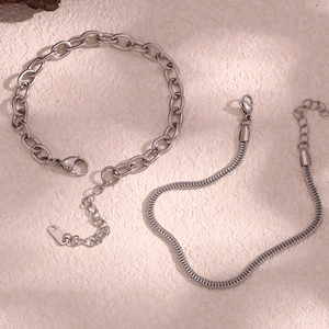 Close-up of silver stainless steel cable and snake chain anklets with lobster clasps