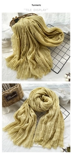 Detail of ginger yellow pleated scarf showing fine crinkle texture and fringe edges